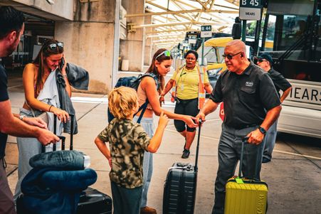 Mears Connect bus driver handling luggage and interacting with a young traveler